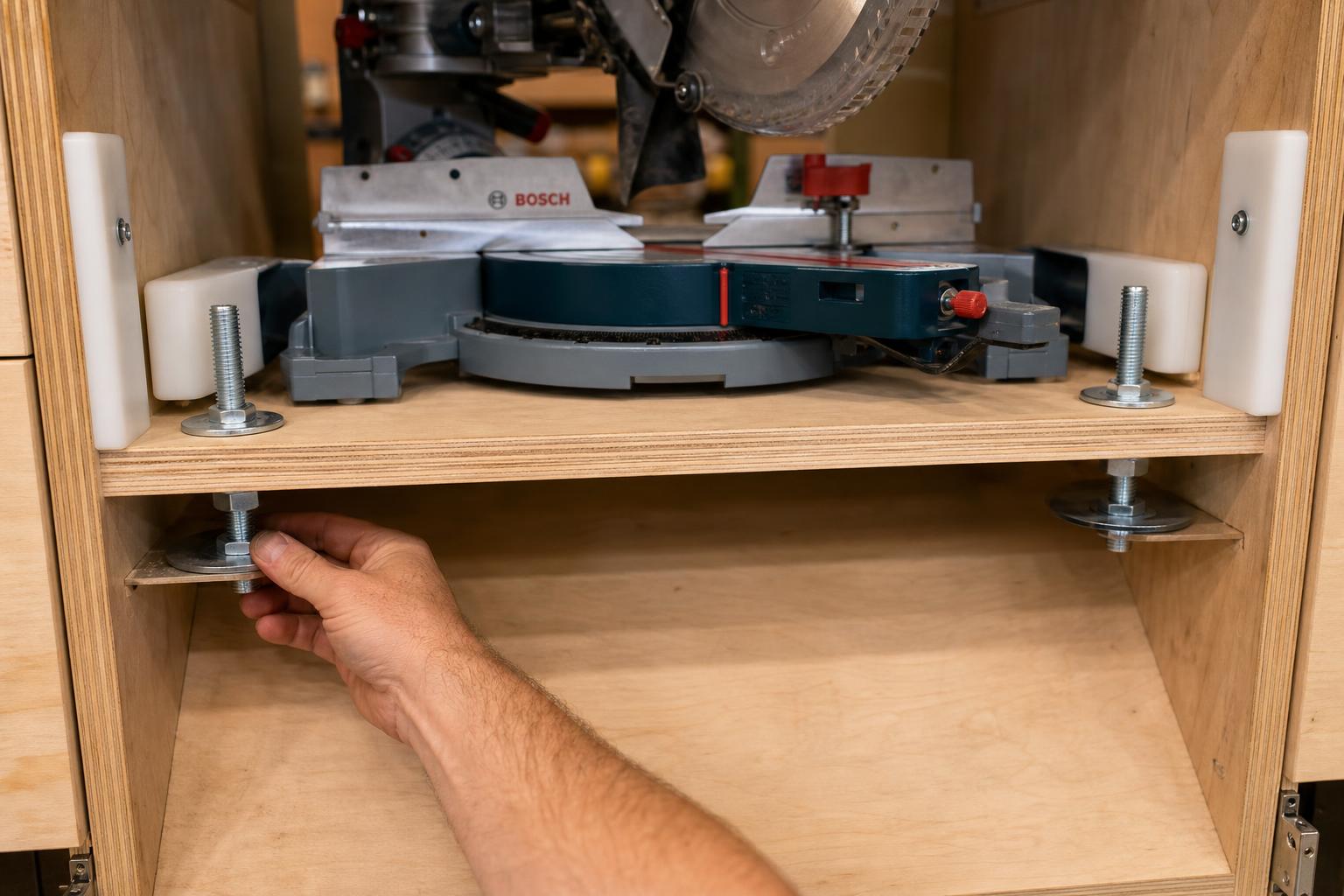 Bosch miter saw platform with jack screws, steel bearing plates, hold-down bolts, and UHMW anti-sway guides adjusted from inside the cabinet below